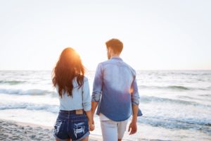 Couple walking at sunrise on the beach